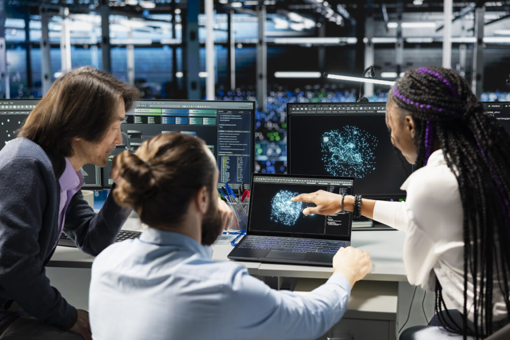 Data center coworkers doing brainstorming, monitoring AI applications, adjusting machine learning. Server hub colleagues working together, enhancing artificial intelligence software performance