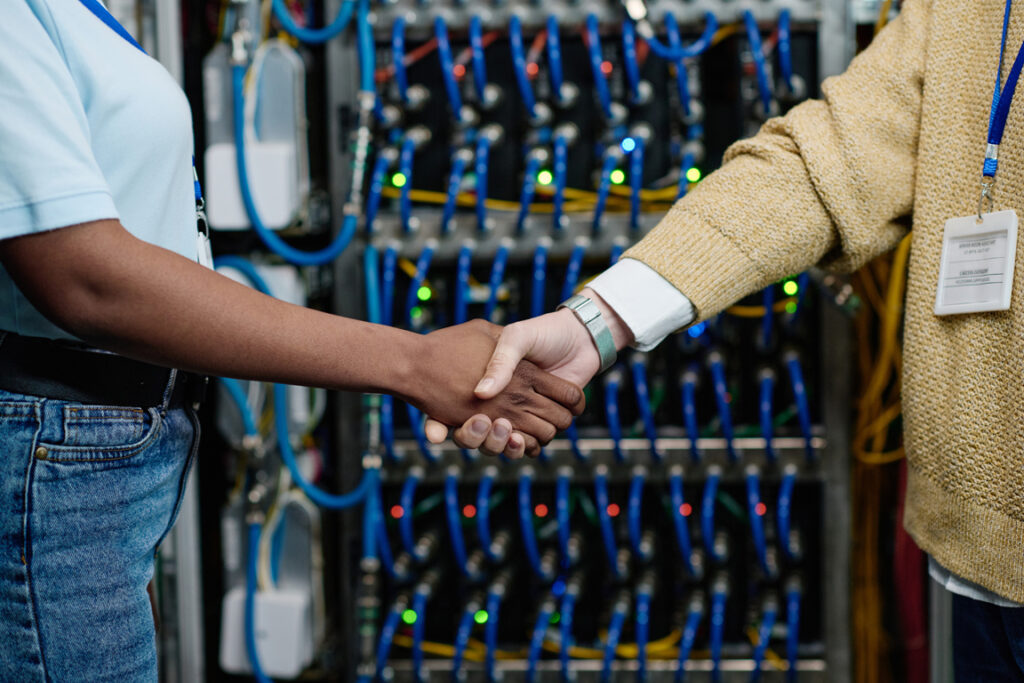 Close-up of female engineers shaking hands to each other during their teamwork in data center