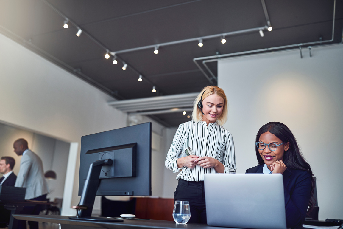 two-diverse-young-businesswomen-smiling-and-lookin