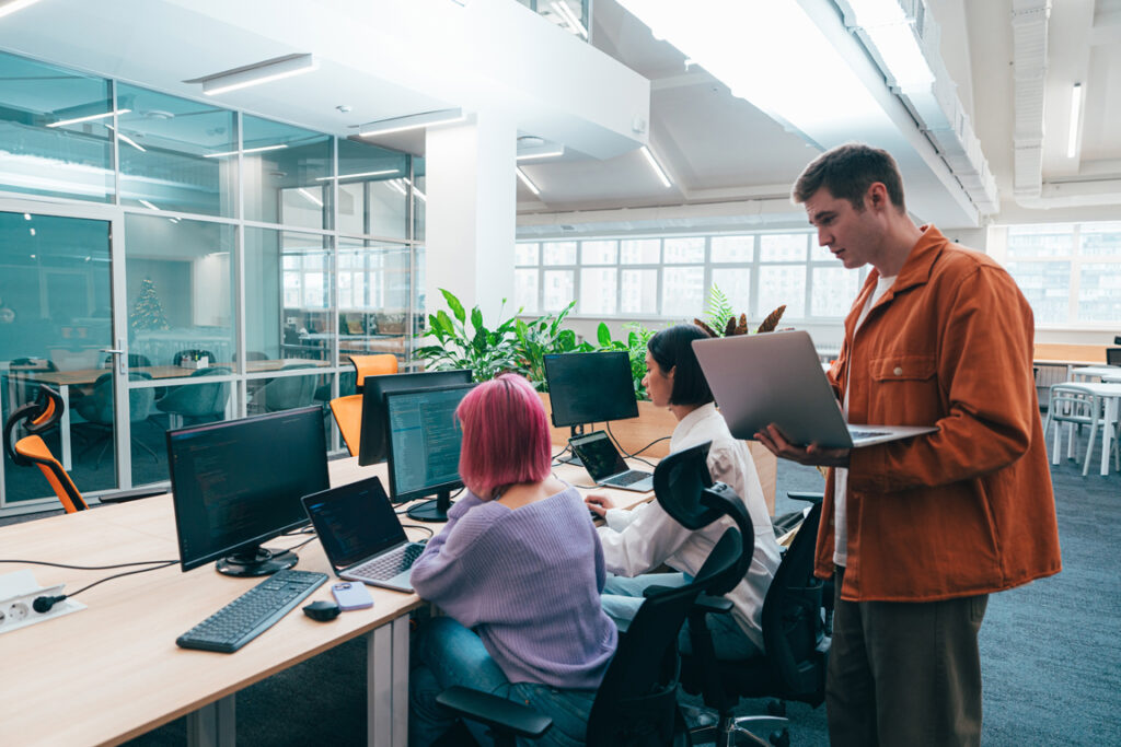 Cinematic image of a programming office with young programmers working on a new project for a start up business.